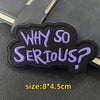 A dark purple embroidered patch shaped like a question mark with the text WHY SO SERIOUS?