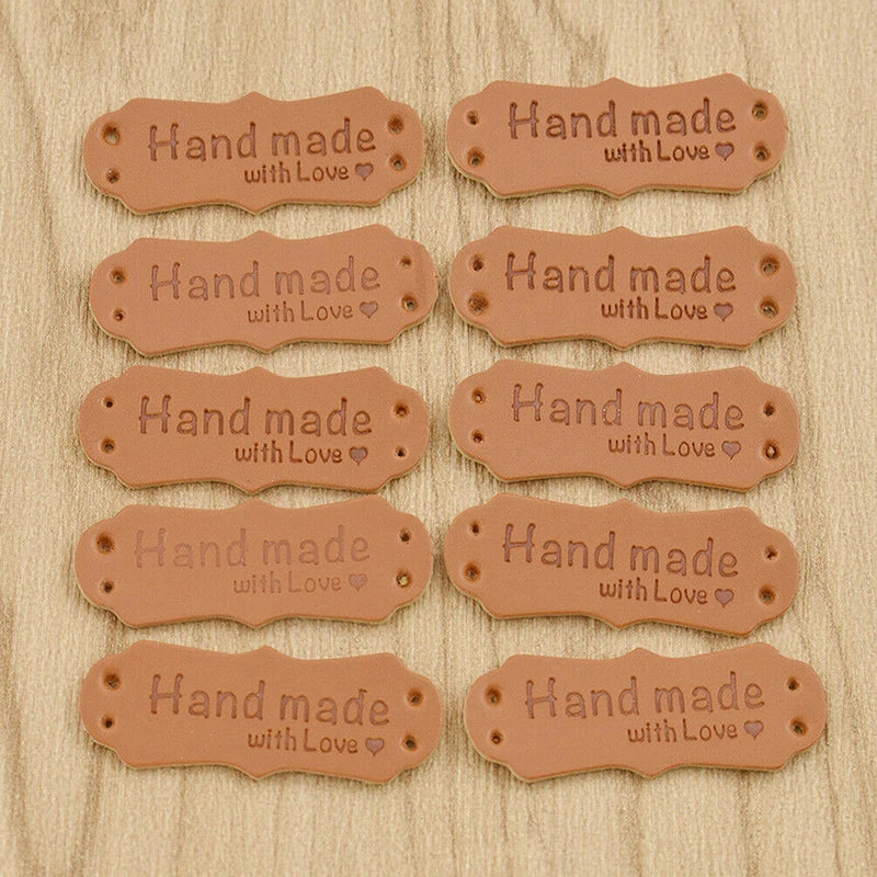A collection of brown PU leather hand made with love sewing labels for handmade crafts.