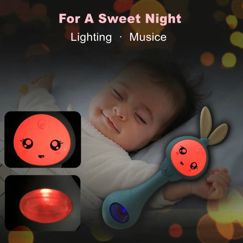 A baby is holding a glowing electronic rabbit rattle and teether toy for a sweet night.