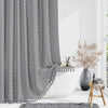 Gray boho waterproof shower curtain with tassels and hooks hanging in a bright bathroom