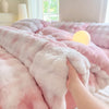 A pink plush fleece duvet cover with a rabbit design is being touched on a bed.