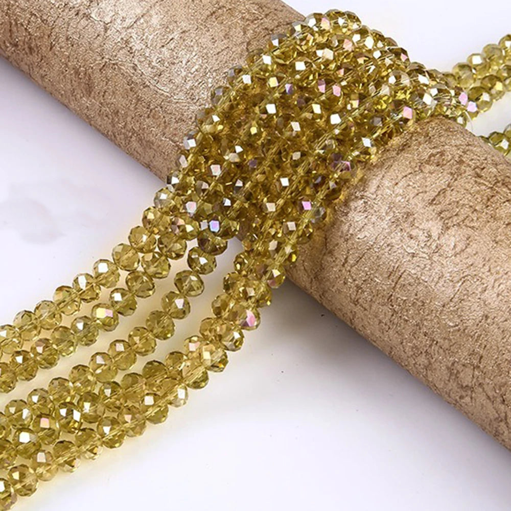 Gold faceted crystal glass spacer beads threaded onto a brown twine or cord.