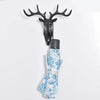 A vintage deer head wall hook featuring antlers, used for hanging hats, scarves, or keys.