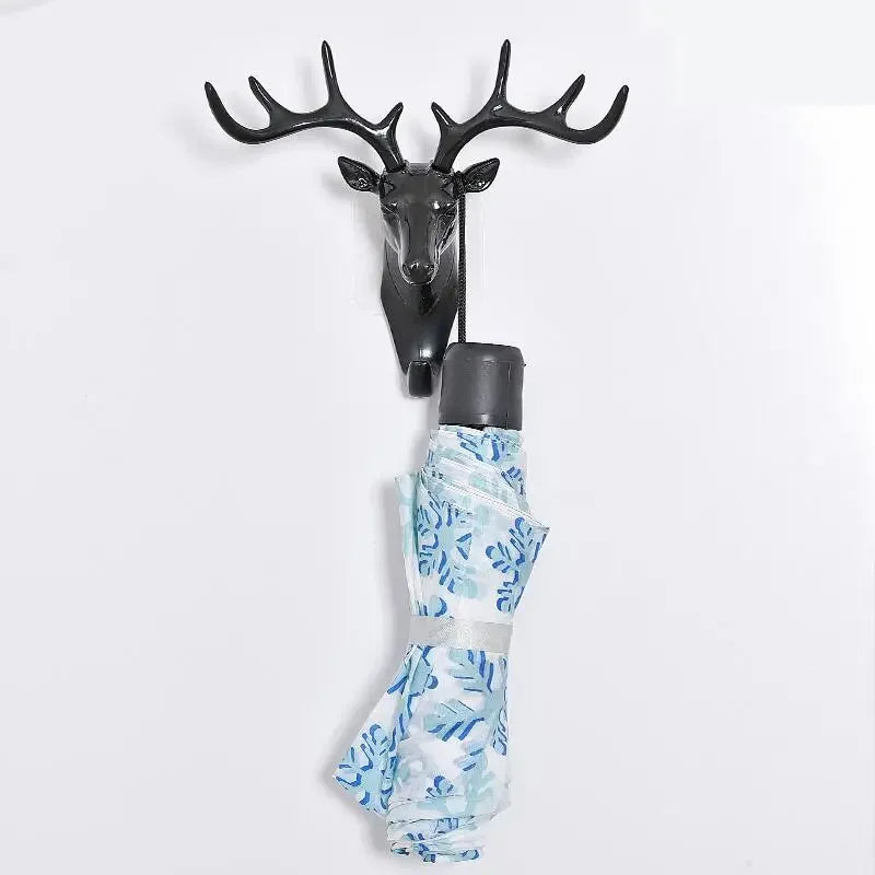 A vintage deer head wall hook featuring antlers, used for hanging hats, scarves, or keys.