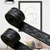 Black 3D embossed peel-and-stick foam wall panels in a decorative scroll pattern mounted on a white frame.