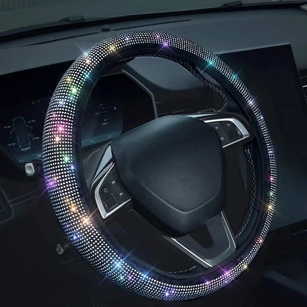 A close-up of a black steering wheel covered in sparkling crystal rhinestones.