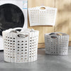 White folding laundry basket with perforated sides and handles displayed on a gray floor.