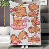 A beige flannel throw blanket featuring a repeating pattern of cute cartoon capybaras and a pink flamingo.