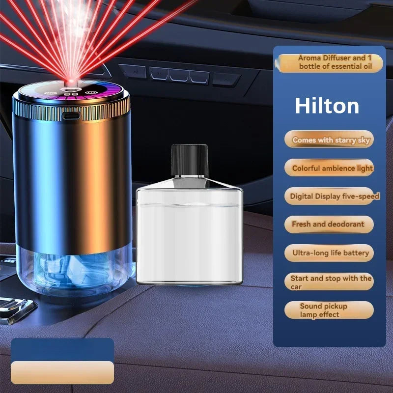 A Hilton rechargeable car aroma diffuser with a starry sky light and essential oil bottle displayed on a dark surface.