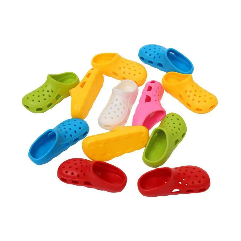 A collection of colorful adhesive wall-mounted toothbrush holders with drainage holes in various shades of green, yellow, and