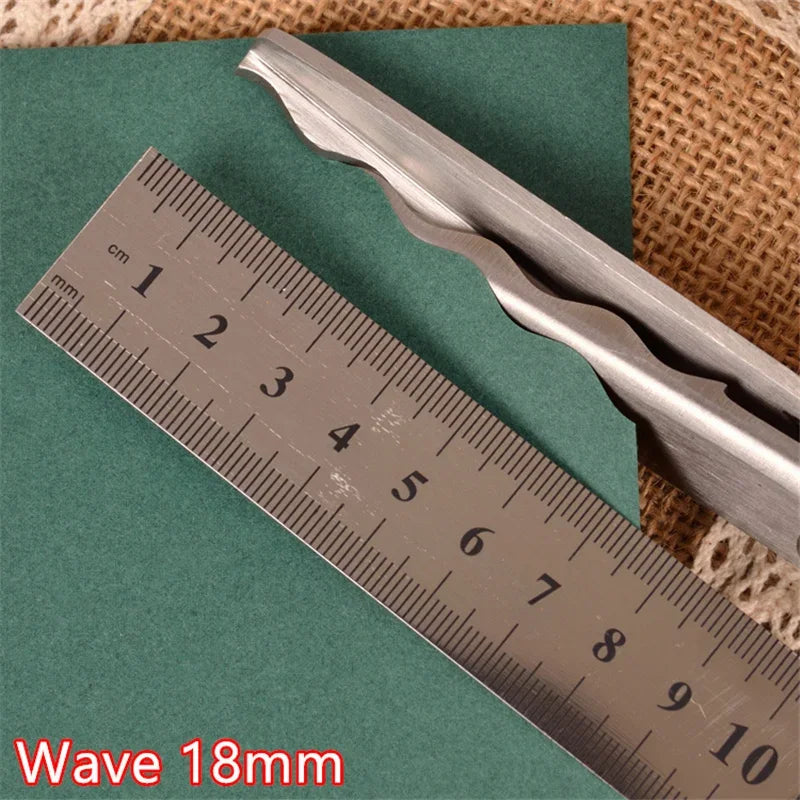 Silver pinking shears shown next to a ruler measuring 10 cm on a green surface.