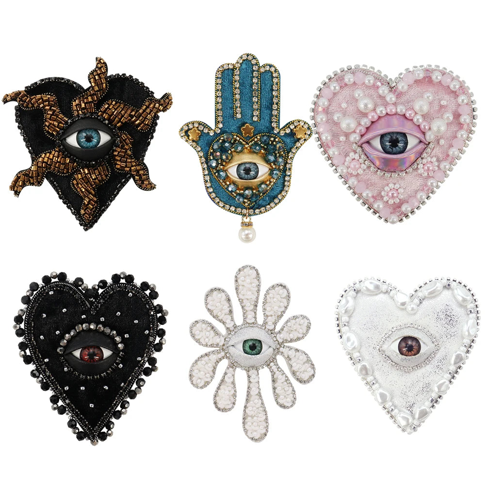 Four sparkling beaded rhinestone patches featuring various eye designs including a black cat, a blue hand, a pink heart, and 