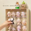 A light wood display case holds various collectible dolls and figurines.