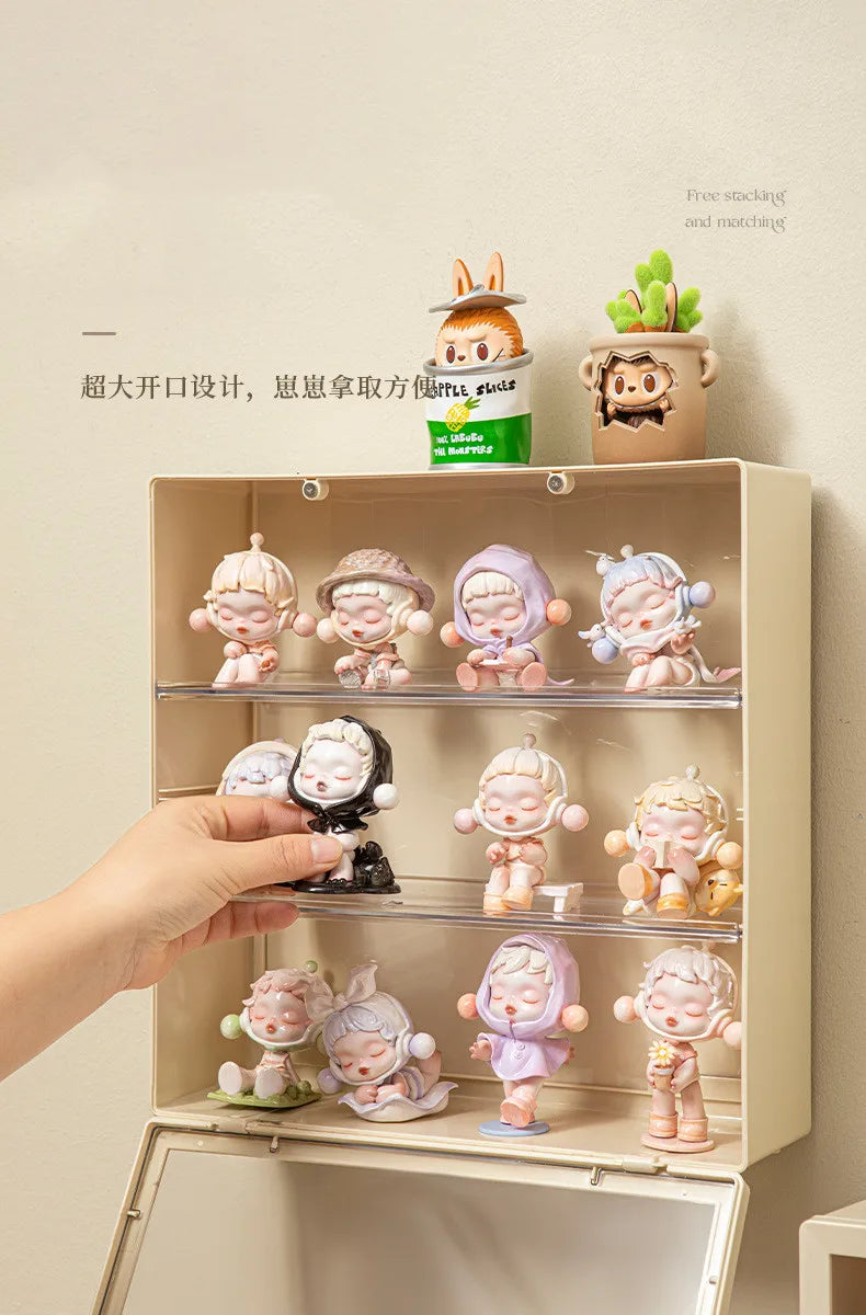 A light wood display case holds various collectible dolls and figurines.