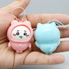 A pink Usagi and blue Hachiware PVC bag pendant doll are held in a person's hand.