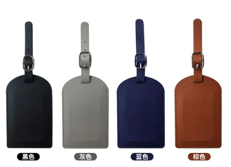 Four luggage tags in black, gray, blue, and brown leather with metal attachments.
