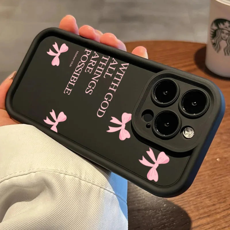 A hand holds a black silicone phone case featuring pink butterfly slogans on the back.