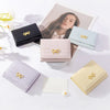 A collection of pink, blue, and cream tri-fold wallets featuring gold bow embellishments.