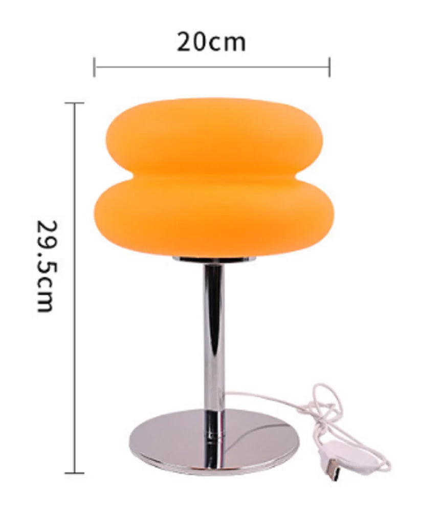 Orange cloud-shaped bedside lamp with a silver stand and remote control.