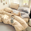 A beige cotton bedding set featuring a flat sheet, duvet cover, and pillowcases on a bed.