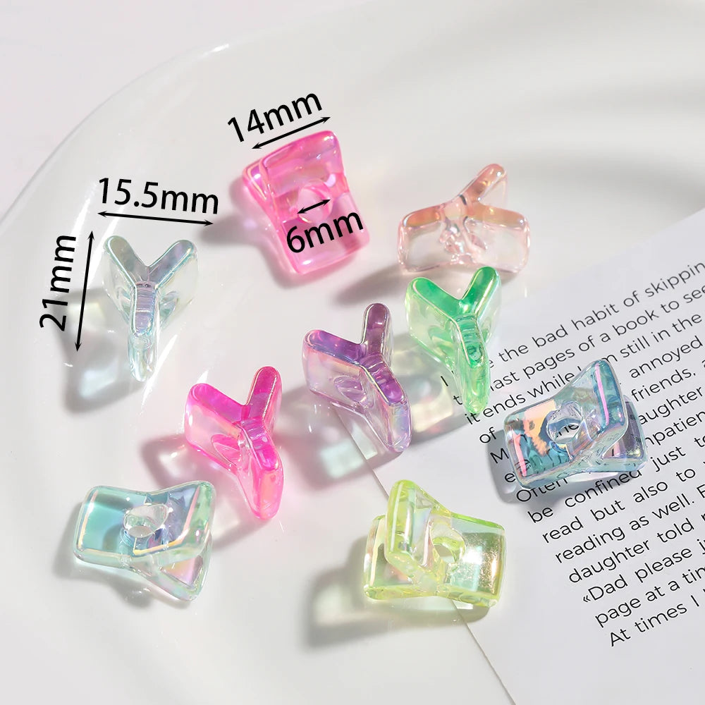 A collection of pink and green acrylic alphabet beads displayed on a white surface with measurement lines.