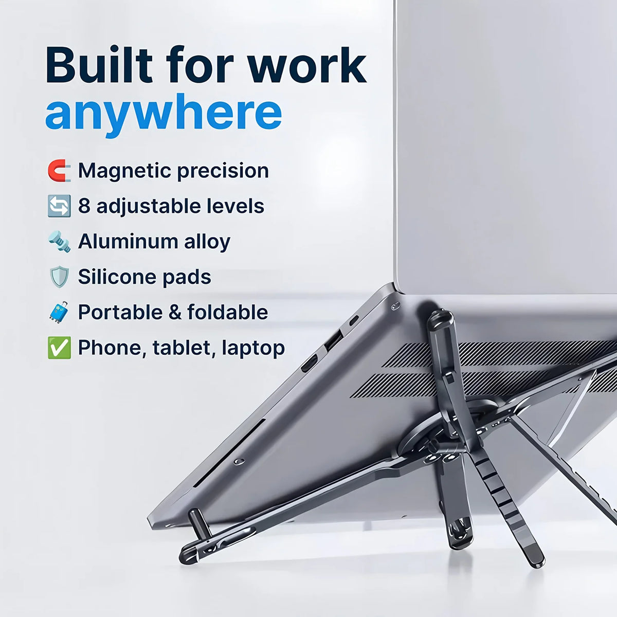 A silver magnetic phone holder and foldable tripod stand is shown resting on a laptop.