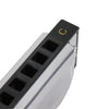 A close-up view of a black and silver harmonica with a gold C key marked on the top.