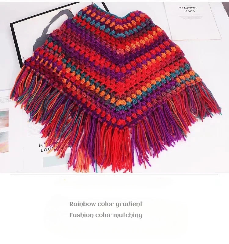 A vibrant rainbow color gradient knitted shawl or garment with fringed edges.