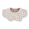 A light floral patterned muslin cotton baby bib with a pink lining and adjustable snap closure.