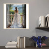 A painting of a woman in a white gown standing by a window with greenery outside.