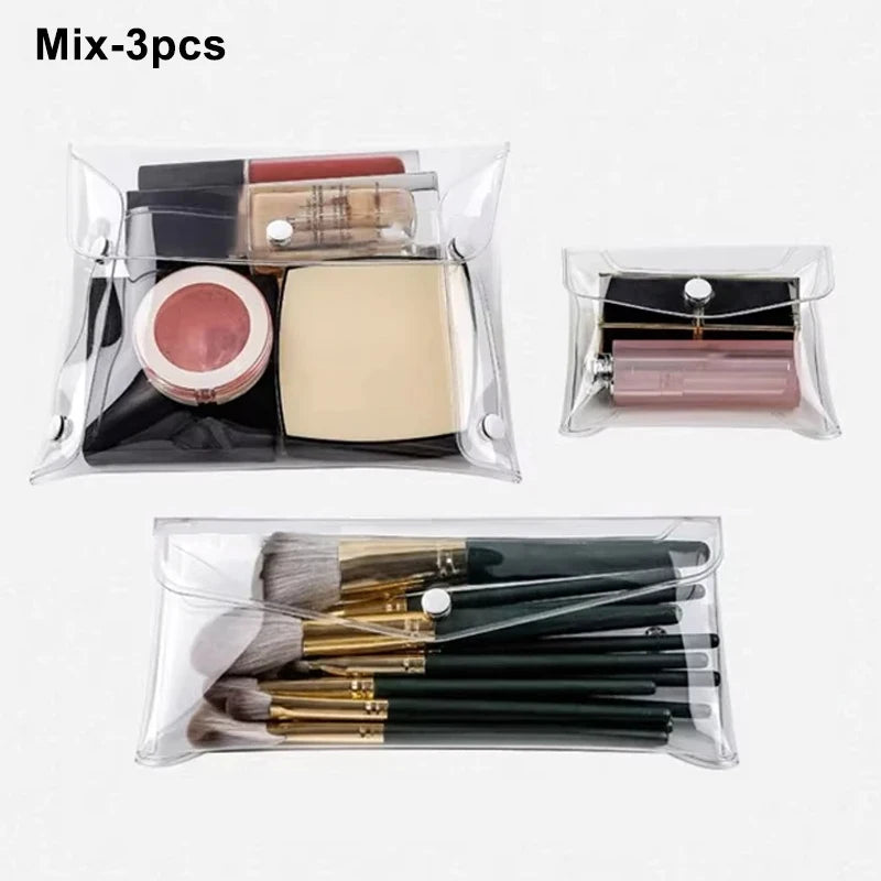 A clear cosmetic bag containing three makeup brushes and a cosmetic tool.