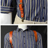 A man wearing a blue and yellow striped shirt with genuine leather double shoulder suspenders.