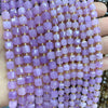 A close-up of purple square faceted beads strung together on a string for jewelry making.