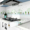 A white kitchen splashback featuring green succulent stickers and a stainless steel hood.