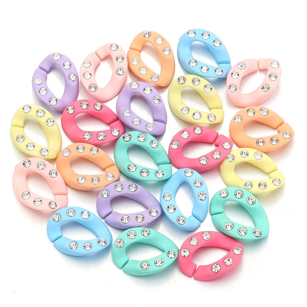 A collection of twenty colorful acrylic jewelry connector clasps with crystal accents in various pastel shades.