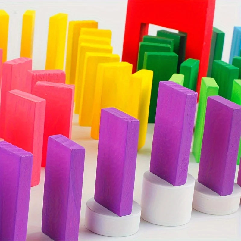 A collection of colorful wooden domino building blocks in various shades of pink, yellow, green, and purple.