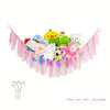 Bohemian handwoven corner toy storage net with colorful stuffed animals and pink tassels