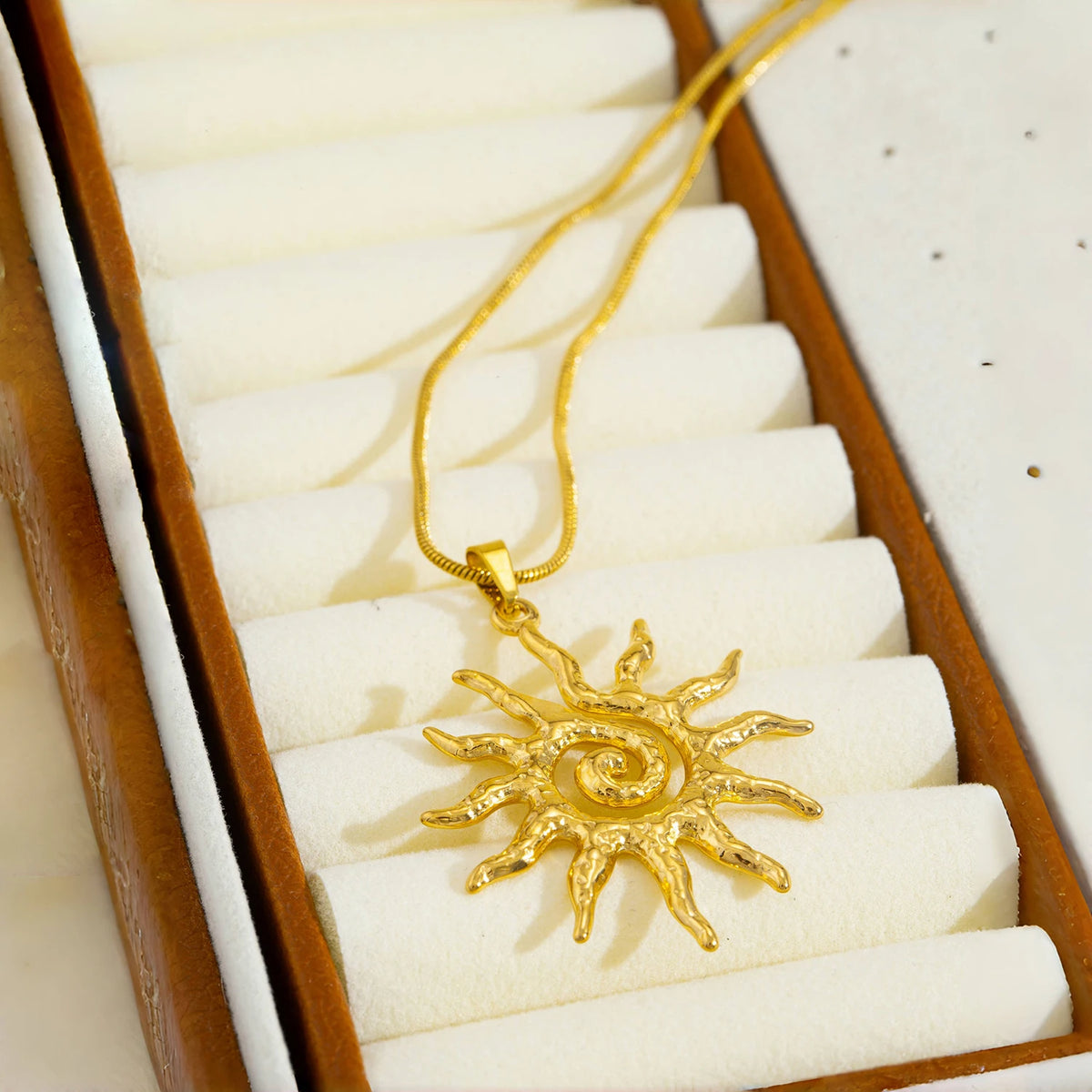 Goldspirale-Sonnenanhangkette in einer Holzschatulle mit weißer Polsterung.