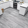 Light gray wood grain floor tiles installed in a modern kitchen with white cabinets and countertops.