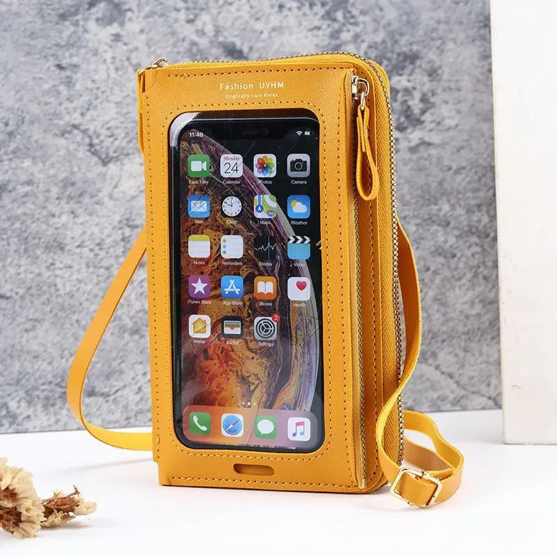 A yellow leather hands-free crossbody phone bag with a clear window displaying a smartphone screen.