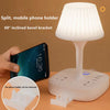 A white split mobile phone holder with a 60 degree inclined bevel bracket and USB charging hub sits on a desk.