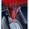 A close-up of a romantic star projection light illuminating a car interior, aimed at a retractable car charger.