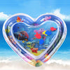 A heart-shaped inflatable water play mat filled with colorful plastic sea creatures for baby sensory development.