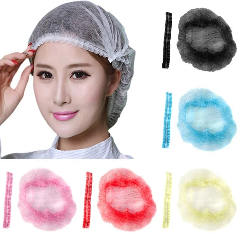 A collection of disposable non-woven hair net caps in various colors including gray, black, blue, pink, red, and yellow.