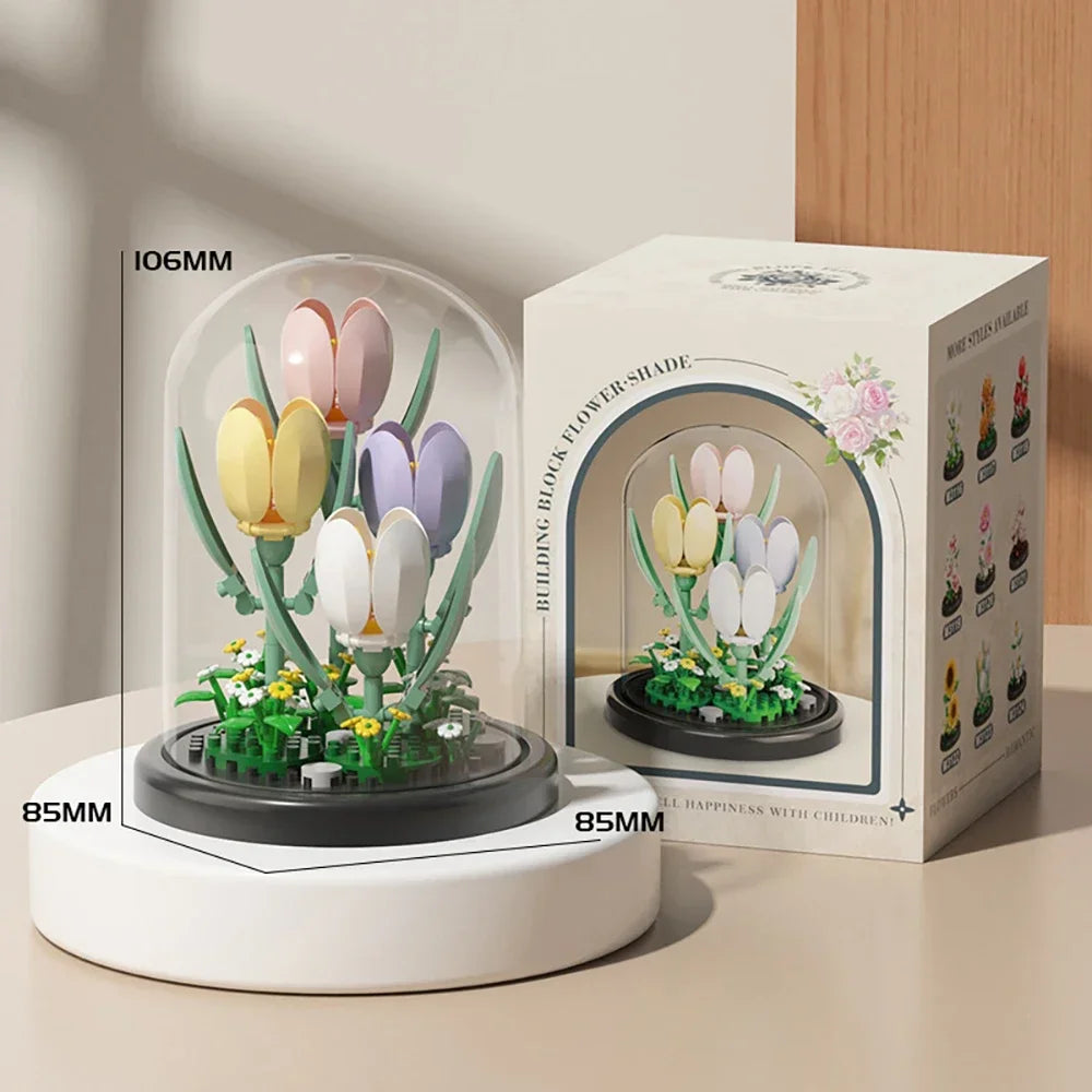 A white building block set featuring a glass enclosure with pink and purple flowers and green stems.