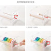 Demonstration of using a plastic tape cutter and storage box for creative washi tape.