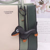 A dark green leather bag featuring a dachshund PU leather keychain with an orange nose and ear.