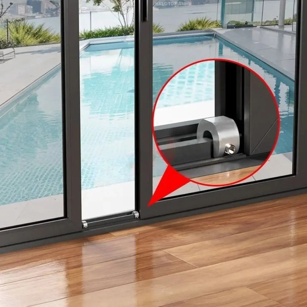 Close-up view of an adjustable aluminum sliding window lock stopper mechanism installed in a glass door frame.