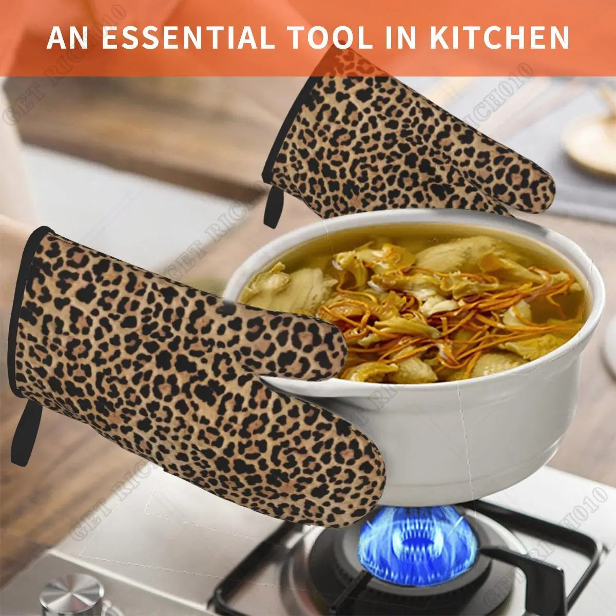 A pair of leopard print oven gloves resting on a stovetop with a bowl of soup in the background.