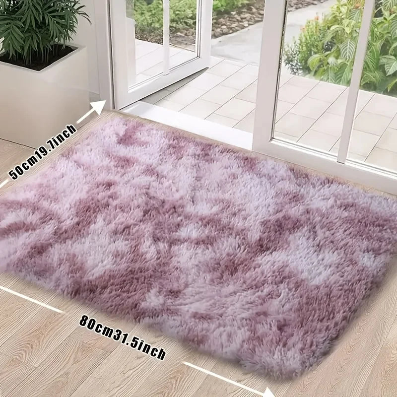 A fluffy mauve area rug placed on a light wood floor near a glass door.